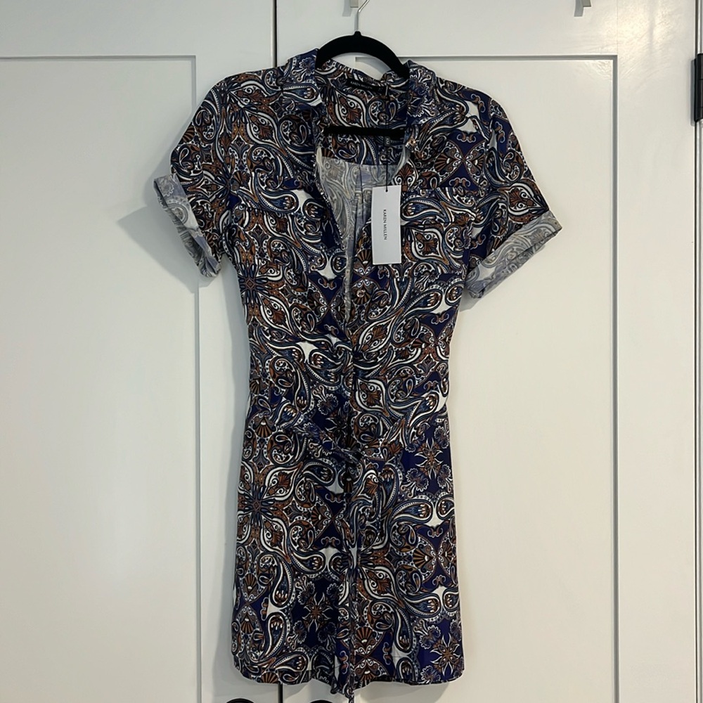 Patterned romper with zipper and button up along with a tie around waist. NEW!!